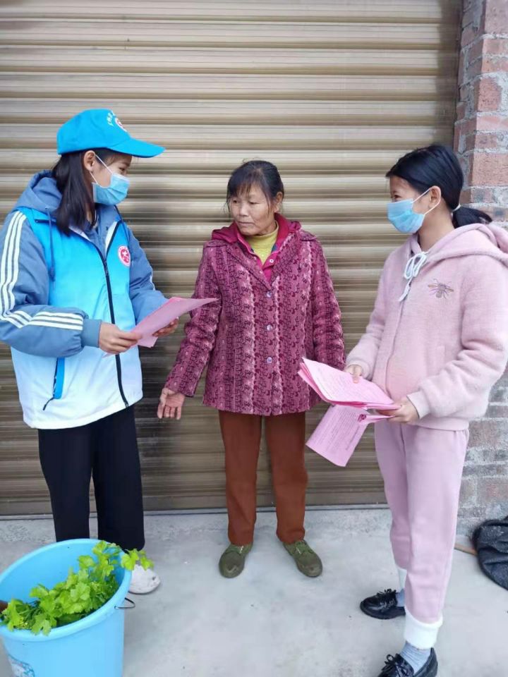 运科院学生韦晓燕正在向村民宣传防疫知识,并督促其佩戴口罩
