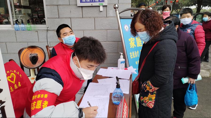 体教院学生刘胡源在医院门口为市民发放中药