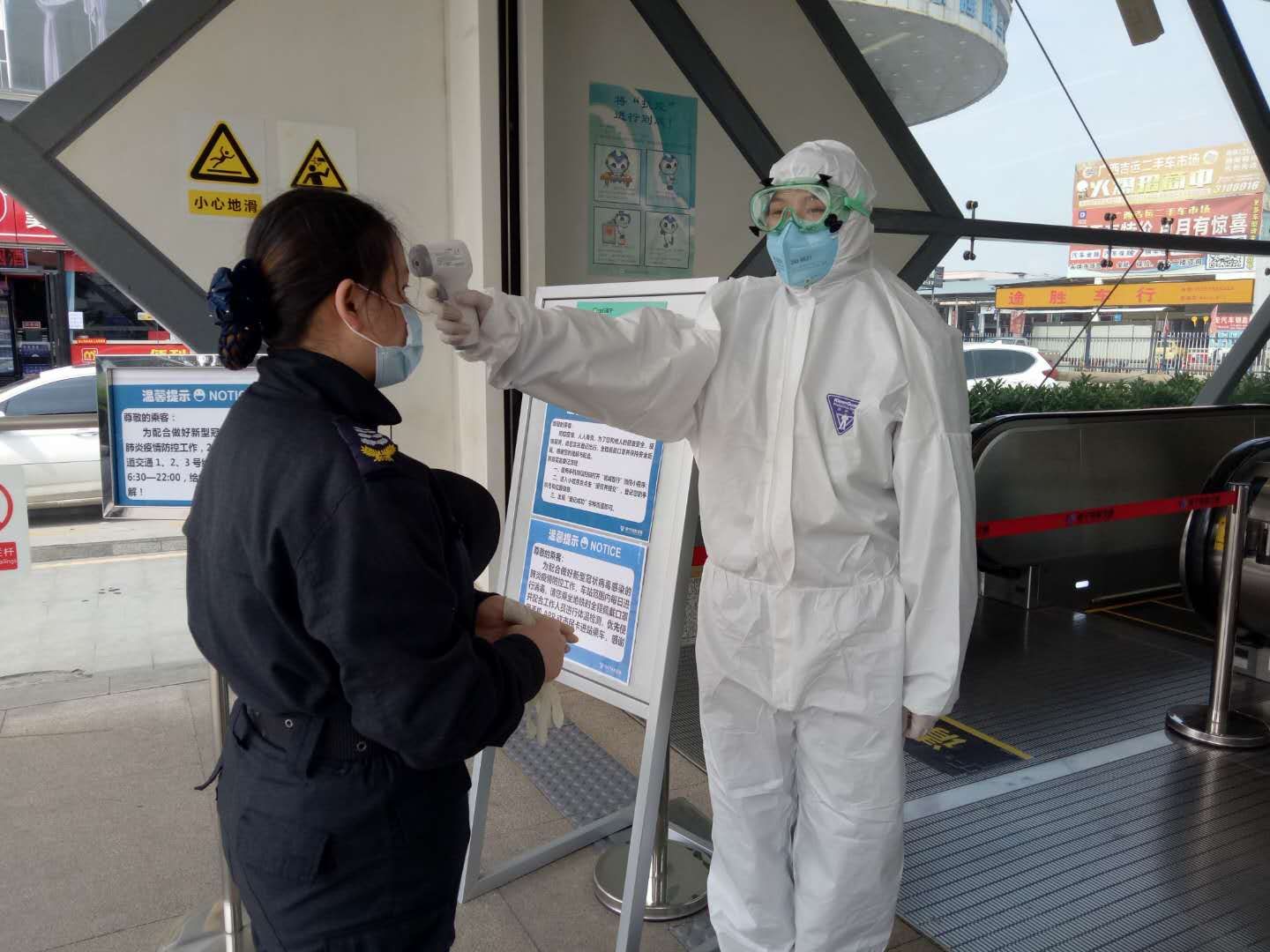 经管院学生肖韦玲在地铁口给群众测量体温