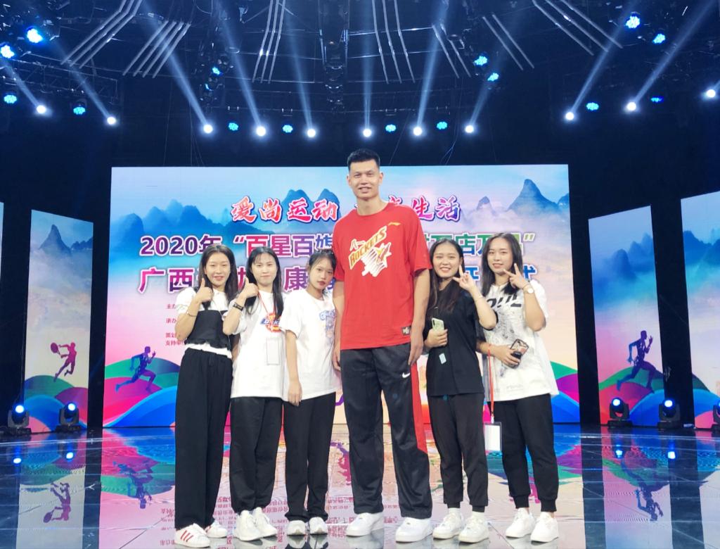 志愿者与中国知名中锋八一篮球队许钟豪合影留念